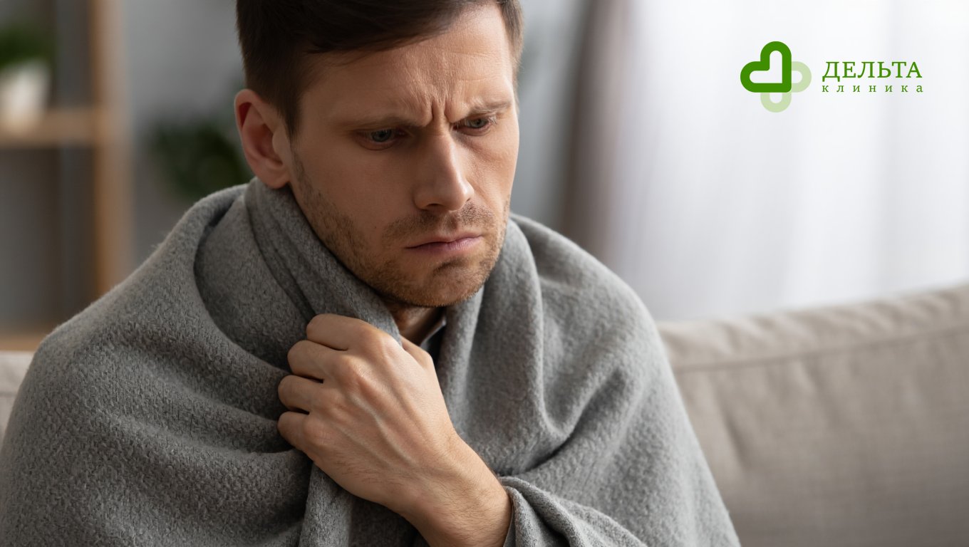 Мужчина обернутый пледом с симптомами алкоголизма